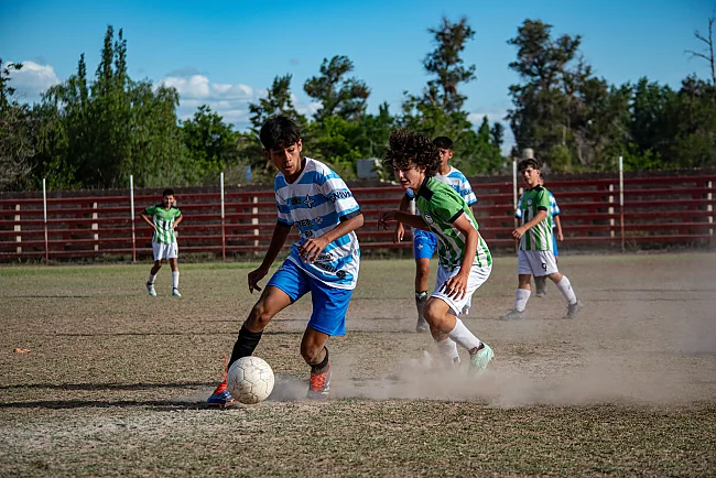 Teenager spielen auf einem sonnigen Außenfeld Fußball und liefern sich einen intensiven Wettkampf | &copy; Franco Monsalvo (Pexels)