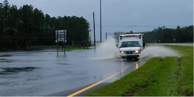 Abbildung 1: Trotz Überschwemmungen in Seminole County, Florida, kämpft sich im August 2008 ein Krankenwagen während des Tropensturms Fay durch überflutete Straßen. | © Barry Bahler/FEMA